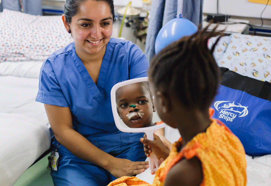 Aminata betrachtet sich nach der Operation ihrer Lippenspalte zufrieden im Spiegel